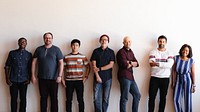 Diverse group of people standing against a wall. Casual attire, mixed ethnicities. Smiling, relaxed, diverse team, diverse group, diverse individuals. Diverse startup business team starting in row.