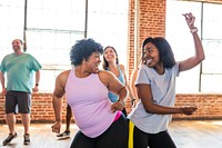 Group dance class with diverse participants enjoying movement. Energetic dance session in a bright studio. Smiling individuals in a lively dance environment. Happy diverse women in dance studio.