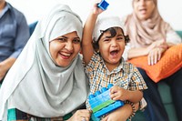 A joyful Muslim mother and her young son share a happy moment together. The smiling mother in a hijab and her excited son, showcasing happy family vibes.