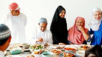 Muslim family and friends enjoying a meal with diverse dishes. Men and women in traditional attire. Smiling, sharing, and enjoying food together at a festive gathering. Muslim family having a feast.