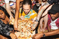 Group of friends enjoying pizza together. Diverse group sharing pizza slices. Hands reaching for pizza. Casual pizza party with friends. Friends celebrating at party.