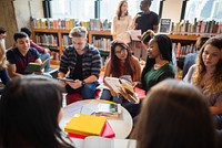 Diverse group of students studying in a library, reading books and using tablets. Young adults engaged in learning, collaborating in a library setting. Diverse young people reading at library.