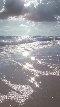 Beach sunlight clouds ocean.