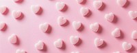 Light pink background with blurred hearts valentine sweets shapes.