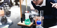 Students conducting a science experiment with beakers and test tubes. Science experiment involves chemical reactions. Engaged students in a lab setting. Science education concept photo.