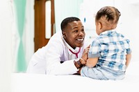 Doctor interacting with a child in a hospital setting. The doctor is smiling and wearing a white coat. The child is sitting on a bed, wearing a plaid shirt. Hospital, medical, and healthcare concept.