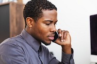 Man talking on phone, focused expression. Office setting, business attire. Man on phone, professional environment. Engaged in conversation, office work. Office worker man in modern office setting.