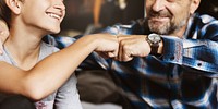 A joyful moment of connection between two father and son, showing a fist bump. Smiling faces, casual attire, and a sense of camaraderie highlight the bond. Father and son photo.