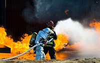 Aaron Weisenberger, front, with the 436th Civil Engineer Squadron fire department, leads a two-person fire attack crew during fire training at Dover Air Force Base, Del., Nov. 4., 2013.