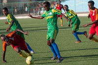 A Horseed player stumbles as a Heegan player tries to steal the ball during a game between Heegan and Horseed football clubs at Banadir Stadium on 31st January 2014. AU UN IST PHOTO / David Mutua. Original public domain image from <a href="https://www.flickr.com/photos/au_unistphotostream/12250674796/" target="_blank" rel="noopener noreferrer nofollow">Flickr</a>