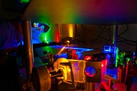 A Sandia researcher examines the set-up used to test diode lasers as an alternative to led lighting. Original public domain image from <a href="https://www.flickr.com/photos/departmentofenergy/13784499855/" target="_blank">Flickr</a>