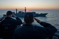 U.S. Navy Cmdr. Andrew Biehn, right, the commanding officer of the guided missile destroyer USS Truxtun (DDG 103), and Cmdr. Andrew Bates, the executive officer of the Truxtun, salute the Romanian frigate ROS Regina Maria (F 222) aboard the Truxtun in the Black Sea March 12, 2014.