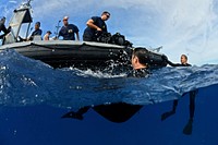 U.S. Navy divers with Mobile Diving and Salvage Unit 1 assist Coast Guard divers following a scuba dive in the Pacific Ocean July 9, 2014, during Rim of the Pacific (RIMPAC) 2014.