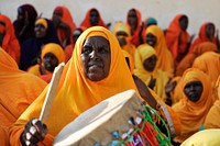 An elderly Woman drums during a game between Halane and G. Da'ud football clubs at Wadajir Stadium in Mogadishu, Somalia on December 23, 3014. AU UN IST Photo / Ilyas Ahmed. Original public domain image from Flickr