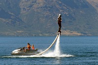 A Flyboard is a type of water jetpack attached to a personal water craft (PWC) which supplies propulsion to drive the Flyboard through air and water to perform a sport known as flyboarding. A Flyboard rider stands on a board connected by a long hose to a watercraft. Water is forced under pressure to a pair of boots with jet nozzles underneath which provide thrust for the rider to fly up to 15 metres in the air or to dive headlong through the water. Original public domain image from Flickr