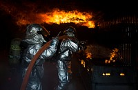 U.S. Air Force firefighters fight flames during a controlled building fire exercise at Ramstein Air Base, Germany on Mar. 19, 2015.