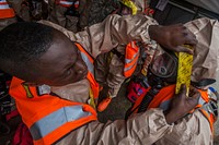 Soldiers with the 2nd-113th Infantry Battalion, 50th Infantry Brigade Combat Team, New Jersey Army National Guard, seal protective suits during a full scale Homeland Response Force exercise involving units from the New Jersey and New York Army and Air National Guard at Joint Base McGuire-Dix-Lakehurst, N.J., April 17, 2015. From April 14-19, 2015, nearly 600 New Jersey and New York Army and Air National Guardsmen participated in the joint-training event with New Jersey Office of Emergency Management and New Jersey State Police Task Force 1. The troops are part of a regional disaster response force trained to respond to a chemical, biological, radiological or nuclear incident. The National Guard Homeland Response Force is one of ten established by the Department of Defense. (U.S. Air National Guard photo by Master Sgt. Mark C. Olsen/Released). Original public domain image from Flickr