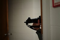 An Atlantic County SWAT member peers around a corner at Atlantic Cape Community College in Hamilton Township, N.J. Members of the New Jersey Air National Guard were invited to evaluate and participate as opposing forces for the annual Atlantic County crisis response exercise.