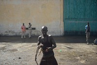 A Somali dock worker holds a piece of rope, used to help and try corral cattle into a nearby pen before they are loaded onto a cargo ship at Mogadishu's seaport on October 29. AMISOM Photo / Tobin Jones. Original public domain image from Flickr