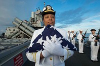 MEDITERRANEAN SEA (Oct. 24, 2015) Lt. j.g. Simone Mims, from New London, Connecticut, holds the national ensign in preparation for a burial at sea ceremony aboard USS Donald Cook (DDG 75) Oct. 24, 2015.