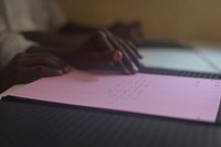 A child at the Al-Nor School for the Blind reads braille using his fingers to feel the letters on the paper while in class in Mogadishu, Somallia. Original public domain image from Flickr