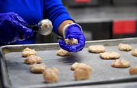 Cookie CrushVolunteers bake thousands of cookies utilizing the Wolf's Den dining facility kitchen on Joint Base Elmendorf-Richardson, Alaska, Nov. 17, 2015. During the cookie drive volunteers collected dough, baked, sorted and packaged the cookies. The cookies will later be delivered to single Airmen and Soldiers living in the dorms and barracks to provide them with a homemade treat during the holiday season. (U.S. Air Force photo/Alejandro Peña). Original public domain image from Flickr