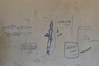 Drawings of weapons and the Al Shabab flag adorn the walls of a building. Original public domain image from Flickr