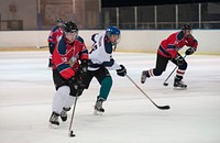 James Lee (left), a member of the Kaiserslautern Military Community Eagles Hockey Team, competes against another teammate for a hockey puck during a practice match in Zweibrucken, Germany on Mar. 16, 2016.