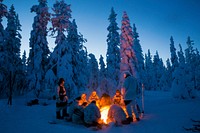 Participants of the Swedish Basic Winter Warfare Course rest in front of a fire during the course&#39;s culminating event in Arvidsjaur, Sweden, Jan. 23, 2018.