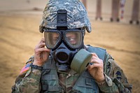 U.S. Army Spc. Jacqueline Robinson, 444th Mobile Public Affairs Detachment, dons her gas mask during the New Jersey Army National Guard’s (NJARNG) Best Warrior Competition at Joint Base McGuire-Dix-Lakehurst, N.J., April 25, 2018. Seven Soldiers, one Airman, and five NCOs competed in the Competition, April 24-26, 2018. The top Soldier and NCO will go on to compete in the Region 1 Competition against National Guard Troops from the six New England states and New York. The Best Warrior Competition is an annual event, which tests their military skills and knowledge, as well as their physical fitness and endurance. (New Jersey National Guard photo by Mark C. Olsen). Original public domain image from Flickr