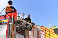 Members of the Mogadishu's Fire and Emergency Response Service serving under the Benadir Regional Administration, atop a fire truck as they take part in a routine morning drill in Mogadishu, Somalia, on 26 May 2018. UN Photo / Omar Abdisalan. Original public domain image from Flickr