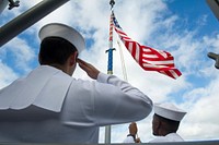 160802-N-FO981-242 JOINT BASE PEARL HARBOR-HICKAM (Aug. 2, 2016) – Fire Controlman Seaman Joshua Kohrs salutes the ensign as it is raised after mooring pier-side at Joint Base Pearl Harbor-Hickam for the conclusion of Rim of the Pacific 2016.