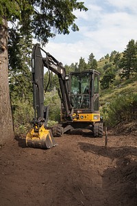 Backhoe, A backhoe was used to remove the majority of the greenery. Idaho Conservation Crew Building a Mountain Bike Flow Trail at the Bogus Basin Ski Resort on the Sawtooth National Forest. Credit: US Forest Service. Original public domain image from Flickr