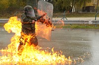 An Albanian soldier of 3rd Infantry Company, 2nd Infantry Battalion extinguishes flames from a molotov cocktail while conducting fire phobia training during a Kosovo Force (KFOR) mission rehearsal exercise (MRE) at the Joint Multinational Readiness Center in Hohenfels, Germany, Oct. 22, 2016.