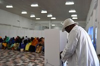 A delegate fills his ballot in a voting booth during Somaliland's ongoing electoral process in Mogadishu, Somalia, on December 14, 2016. AMISOM Photo / Ilyas Ahmed. Original public domain image from <a href="https://www.flickr.com/photos/au_unistphotostream/31603853606/" target="_blank" rel="noopener noreferrer nofollow">Flickr</a>