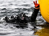 A U.S. Sailor assigned to Explosive Ordnance Disposal Mobile Unit 1, Platoon 122, signals to the boat crew before a mine countermeasure dive in the Puget Sound off Oak harbor, Wash., Oct. 27, 2018.
