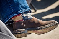 Iowa Senator Joni Ernst wears boots with the American flag during Agriculture Secretary Sonny Perdue visit to Nevada, Iowa to tour Couser Cattle Company, May 5, 2017. USDA photo by Preston Keres. Original public domain image from Flickr