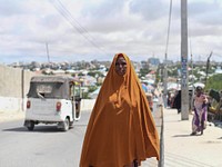 Habibo Mohamud Abdi walks on the sidewalk of a road in downtown Mogadishu, Somalia, on the first day of the holy month of Ramadan on May 27, 2017. AMISOM Photo / Omar Abdisalan. Original public domain image from Flickr
