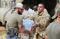 Soldiers from the 1st Armored Division Combat Aviation Brigade and agents with the San Juan Federal Bureau of Investigation unload the CH-47 Chinook helicopter’s supply of food and water from FEMA to the residents of Utuado, Puerto Rico, Oct. 18, 2017, following the devastation caused by Hurricane Maria.