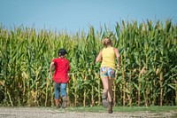 The Brodale children: Isabelle, 10, and Hunter Brodale, 7, race on a farm outside Humbolt, Iowa, while their father works the cattle nearby, Sept. 17, 2017.USDA Photo by Preston Keres. Original public domain image from Flickr