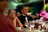 President Barack Obama smiles while watching the entertainment at the State Dinner for Prime Minister Manmohan Singh of India and his wife, Mrs. Gursharan Kaur, left, held inside a tent on the South Lawn of the White House, Nov. 24, 2009.