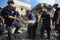 A member of the Los Angeles County Fire Department Search and Rescue team shovels dirt away from a collapsed building in downtown Port-au-Prince, Haiti, Jan. 17, 2010.