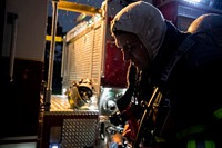 A firefighter preps gear prior to live burn training at the Anthony "Tony" Canale Training Center in Egg Harbor Township, N.J., Sept. 18, 2018. New Jersey state and Delaware Air National Guard firefighters teamed up with civilian instructors for the training that focused on fire suppression in small structures. (U.S. Air National Guard photo by Master Sgt. Matt Hecht). Original public domain image from Flickr