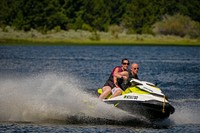 A family rides rides their jet ski on Delmoe Lake in Beaverhead-Deerlodge National Forest.