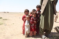 Afghan children stand next to their father