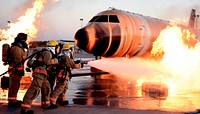 U.S. Air Force Airman Kristina Schneider, right, 312th Training Squadron student, approaches an exterior aircraft fire with a water hose outside the Louis F. Garland Department of Defense Fire Academy at Goodfellow Air Force Base, Texas, Aug. 16, 2019.