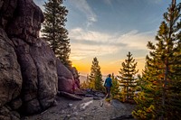 U.S. Forest Service Recreation Forrester Jocelyn Dodge views the sunrise over the Whitetail Mountains from the East Ridge near Butte, Montana, September 15, 2019.USDA Photo by Preston Keres. Original public domain image from Flickr