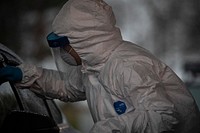 A medical technician works with patients at a COVID-19 Community-Based Testing Site at the PNC Bank Arts Center in Holmdel, N.J., March 23, 2020.