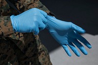 200329-M-VO343-1257 LOS ANGELES (March 29, 2020) U.S. Marine Corps Pfc. Brandon Schim, a rifleman with Bravo Company, 1st Battalion, 4th Marine Regiment, 1st Marine Division, puts on latex gloves outside of hospital ship USNS Mercy (T-AH 19) in Los Angeles, California, March 29.