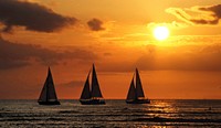 Hawaiian Sunset. Waikiki beach.One of the most well-known beaches on the planet, this 2-mile stretch of white sand and calm turquoise blue ocean fringed by towering high-rises and boutique resorts is located on the South Shore of Oahu. Original public domain image from Flickr